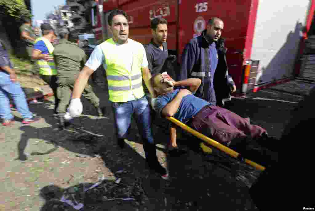 Служащие отряда гражданской обороны помогают раненым. Место взрыва у иранского посольства в Бейруте. 19 ноября 2013 года