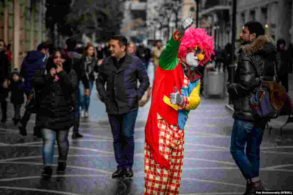 A clown tries to attract customers for a shop in central Baku.