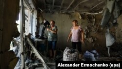 Жінки оглядають свою зруйновану після бойових дій квартиру в місті Ясинувата, Донецька область, 1 серпня 2016 року