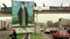 An Iranian woman passes a huge portrait of late Ayatollah Khomeini, 07 June, 1999 in Tehran, as Iran commemorates the tenth anniversary of the Ayatollah's death.