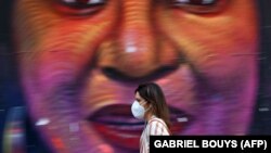 Një grua ec pranë një grafiti në rrugët e Madridit në Spanjë.