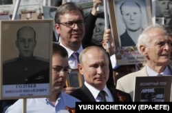 Russian President Vladimir Putin (center) and Serbian President Aleksandar Vucic amid Russians carrying portraits of their relatives who participated in World War II during the Immortal Regiment rally in Moscow.