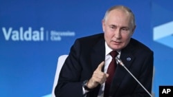 Russia - Russian President Vladimir Putin gestures while speaking at the annual meeting of the Valdai Discussion Club in Sochi, October 5, 2023.
