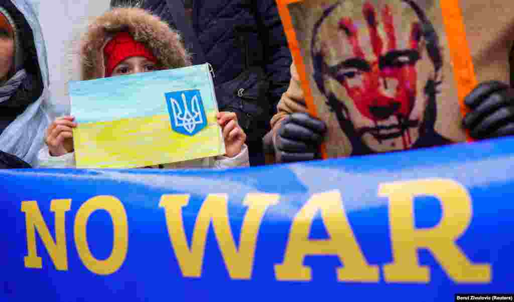 A girl holds a drawing as anti-war demonstrators protest in Ljubljana, Slovenia, on February 25.
