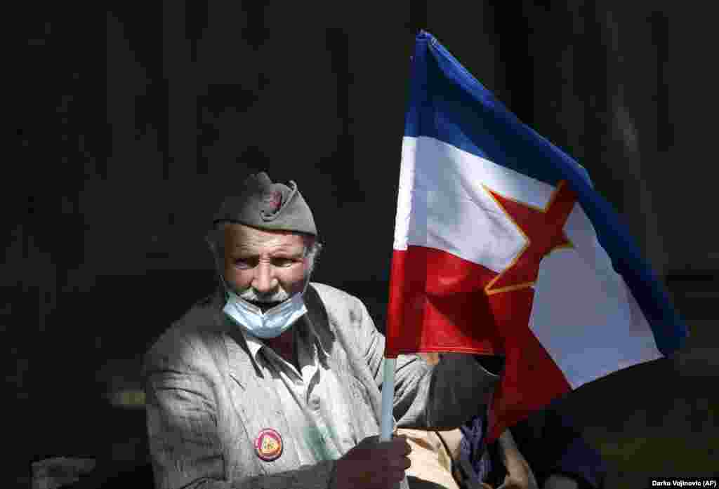 A supporter of Josip Broz Tito holds an old Yugoslav flag prior to a wreath-laying ceremony in Belgrade on May 25 to mark the 129th anniversary of the late communist dictator&#39;s birth.&nbsp;