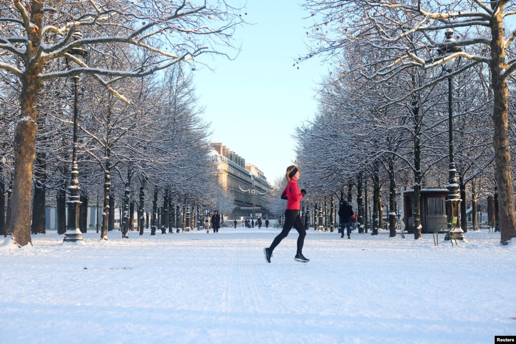 Një grua vrapon në Kopshtin Tuileries të mbuluar me borë në Paris, ndërsa moti dimëror me borë dhe temperatura të ulëta ka përfshirë një pjesë të madhe të vendit, Francë, më 6 janar 2026.