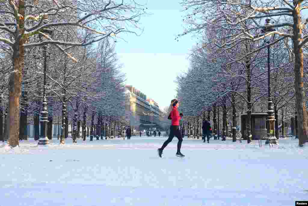 Žena trči kroz snijegom prekriveni vrt Tuileries u Parizu, dok je zimsko vrijeme sa snijegom i niskim temperaturama zahvatilo veliki dio Francuske, 6. januara 2026.