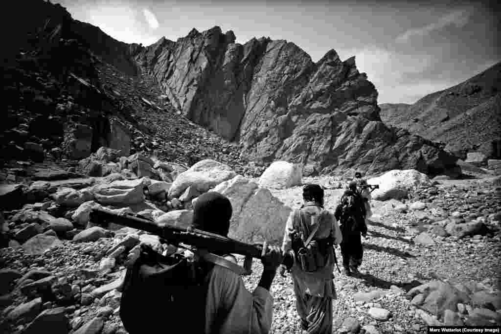 During the intense afternoon heat, Baloch Liberation Army guerillas travel along the floor of a valley in territory under their control.