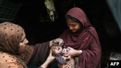 A health worker administers polio drops to a child during a door-to-door vaccination campaign in Lahore, Pakistan, on October 28.