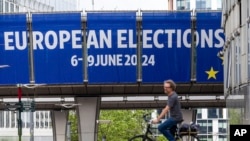 Un bărbat merge cu bicicleta în afara Parlamentului European înainte de o dezbatere cu candidații la alegerile europene de la Bruxelles, joi, 23 mai 2024. Alegerile europene vor avea loc în perioada 6-9 iunie 2024. 