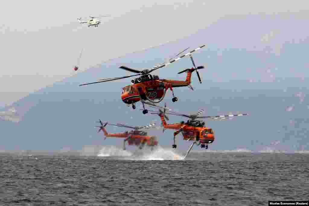 Helikopterët zjarrfikës duke u furnizuar me ujë nga deti për shuarjen e zjarreve në fshatin Pefki, në ishullin e Evias, në Greqi. (10 gusht)