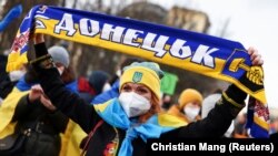 O demonstrantă cu o eșarfă pe care scrie „Donețk”, la un protest desfășurat sub lozinca „Alături de Ucraina”, împotriva uneiposibile invadări a Ucrainei de cătreRussia, Berlin, 19 februarie 2022.