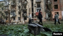 Local residents walk near an apartment building damaged by a Russian air strike in Kharkiv on May 5.