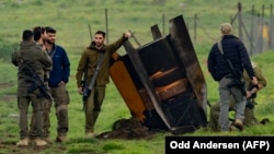 Израильские военные оцепляют территорию вокруг ракеты, выпущенной "Хезболлой" и упавшей в поле на аннексированных Израилем Голанских высотах, граничащих с Ливаном. 19 марта 2026 года