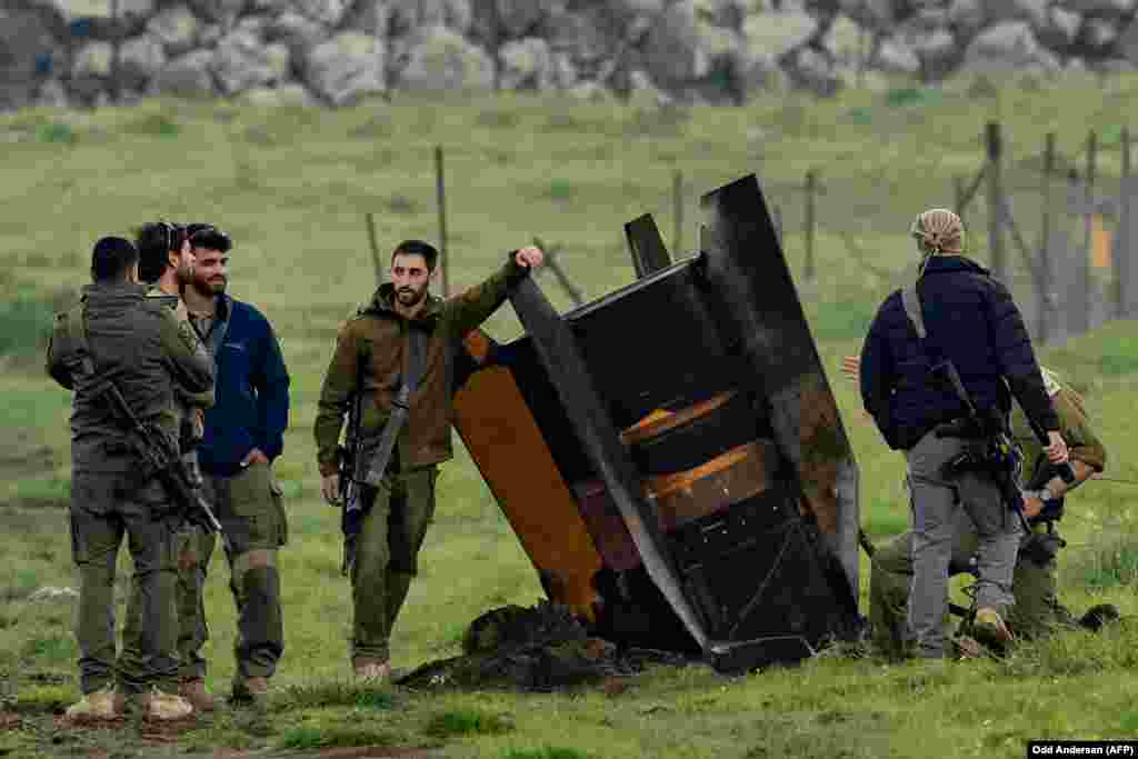 Israeli security personnel gather around a rocket that slammed into a field in the Golan Heights, bordering Lebanon, on March 19.