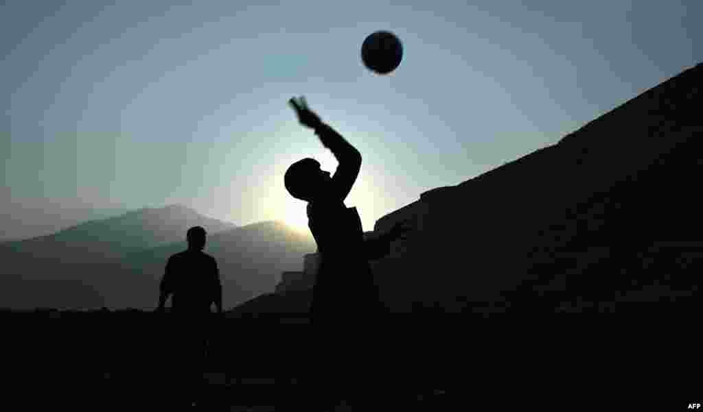 Afghan boys play volleyball as the sun sets in Kabul. (AFP/Wakil Kohsar)