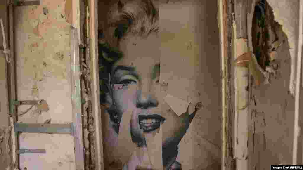 На стене &ndash; часть плаката с изображением Мэрилин Монро