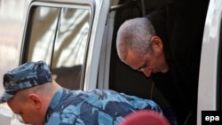 Police escort Mikhail Khodorkovsky to a Moscow courthouse on April 9.