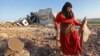 زنی در حال جمع‌آوری آن‌چه از حمله هوایی به ساختمانی در کفرنبل باقی‌ مانده، است. گروه‌های جهادی و دیگر شورشیان سوری بخش‌هایی از ادلب را در کنترل خود دارند؛ جایی‌که میلیون‌ها غیرنظامی سوری ساکن آن هستند.