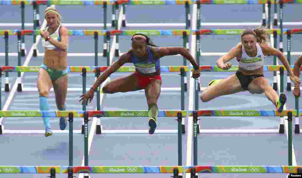 Ekaterina Voronina of Uzbekistan (left to right), Evelyn Aguilar of Colombia, and Ivona Dadic of Austria compete in the women's heptathlon 100-meter hurdles.