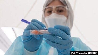 Një punonjëse shëndetësore në Kazakistan duke shënuar mbi një mostër të testit ndaj COVID-19.