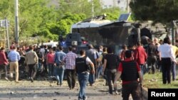 Police and security officers gather at the scene following a car bomb attack on a police vehicle in the Kurdish-dominated southeastern city of Diyarbakir on May 10.