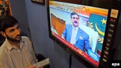 Njerëzit në Pakistan e shikojnë raportin në televizion për diskulifikimin e Gilanit 