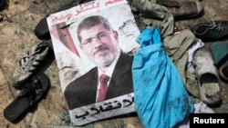 A poster of deposed Egyptian President Muhammad Morsi that reads "No to the coup" lies amid the debris of a protest camp in Cairo.