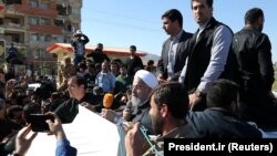 Iranian President Hassan Rohani (C) speaks as he visits Sarpol-e Zahab county in Kermanshah that was hit by a powerful earthquake, November 14, 2017