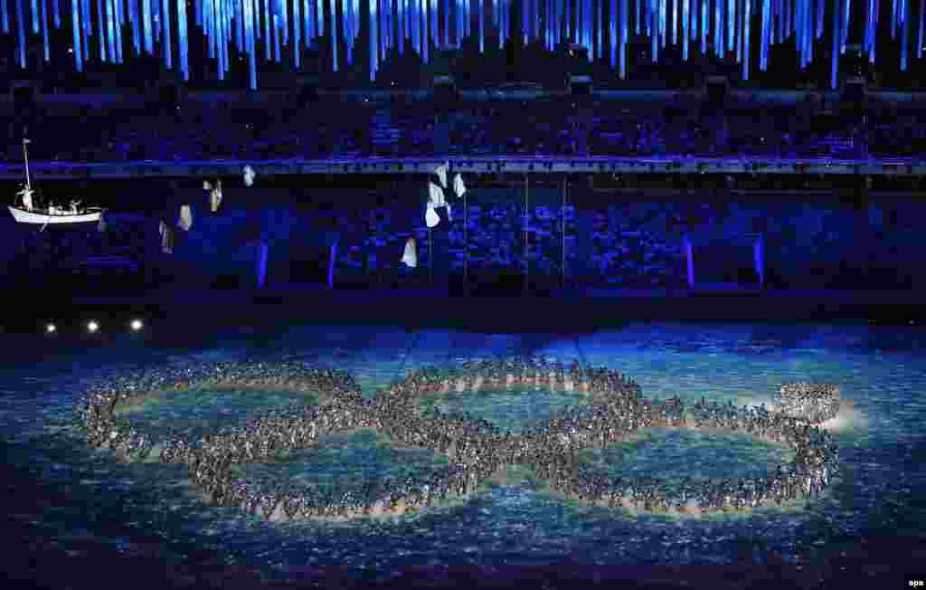 Dancers create the incomplete Olympic Rings during the closing ceremony. (EPA/Barbara Walton)