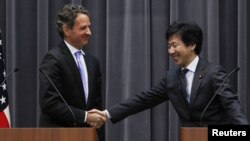 U.S. Treasury Secretary Timothy Geithner (left) shakes hands with Japan's Finance Minister Jun Azumi during a joint news conference at the Finance Ministry in Tokyo on January 12.