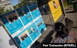 Женщина смотрит на листовки с изображением президента Казахстана Касым-Жомарта Токаева. Алматы, 15 мая 2019 года