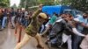 An Indian policeman uses a baton to disperse demonstrators during a protest by government employees demanding their long pending arrears and a regularisation of their temporary jobs, according to protesters, in Srinagar, on May 24.