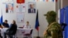 Голосування за кандидатів у депутати Держдуми РФ під наглядом озброєного чоловіка у військовій формі без розпізнавальних знаків, окупований Донецьк, 20 вересня 2026 року