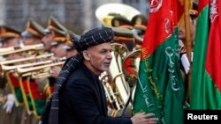 Afghan President Ashraf Ghani inspects the honor guards during a ceremony to introduce his new cabinet to the parliament on January 20.