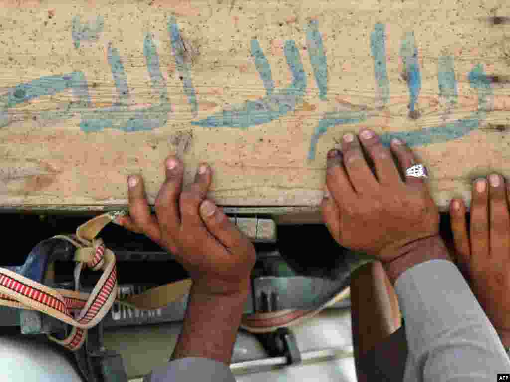 Men in the Iraqi city of Najaf carry the coffin of a relative killed in an election-day attack. - Iraqi Prime Minister Nuri al-Maliki has emerged as the front-runner after the March 7 election, which was marred by accusations of fraud and outbreaks of violence in a number of cities. Photo by Qassem Zein for AFP