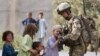 A British soldier shows his rifle to Afghan children during a patrol near the town of Lashkar Gah in Helmand Province. Most U.S. and British troops will be leaving the province by the end of 2014.