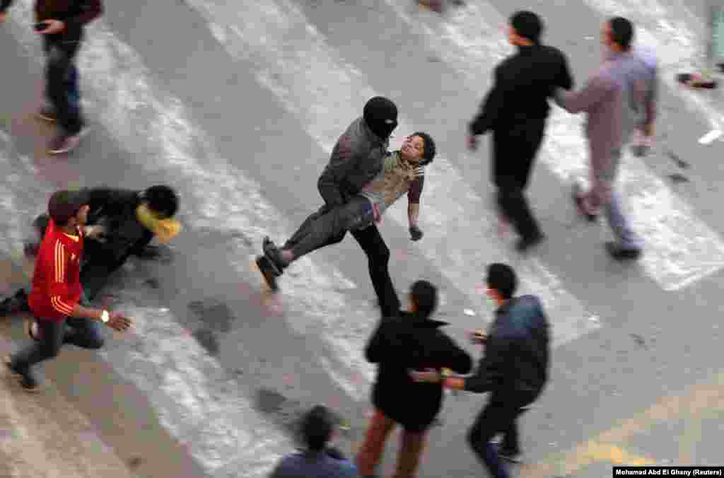 People flee from tear gas fired by riot police after protesters removed a concrete barrier near Tahrir Square in Cairo on January 24. 