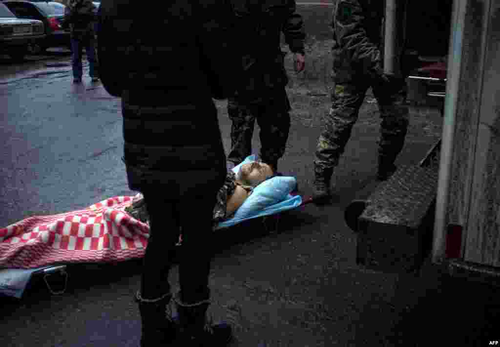 Ukrainian servicemen bring a wounded comrade to a hospital in the eastern Ukrainian city Artemivsk, in the Donetsk region.