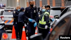 Сотрудники полиции на контрольно-пропускном пункте в Нью-Йорке (США) во время пандемии коронавируса. 