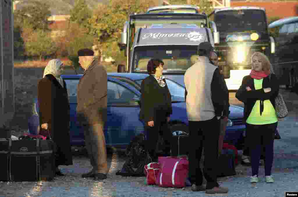 Ethnic Albanians wait for a bus to travel to the EU.