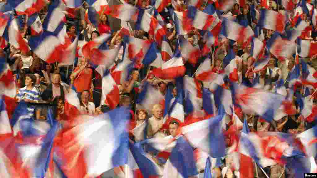 Supporters of French presidential candidate Nicolas Sarkozy wave flags ahead of a political campaign rally in Toulon. (Reuters/Jean-Paul Pelissier)