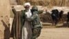 An Afghan soldier frisks a farmer during a patrol near Marjah. Can the Afghan government and its NATO allies win public support there?