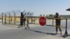 Uzbek soldiers near Termez guard a checkpoint on August 15, two kilometers from a bridge over the Amu Darya River that separates Uzbekistan and Afghanistan.