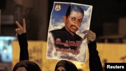 A protester holds a poster of activist Abdulhadi al-Khawaja during an antigovernment rally in Manama in April.