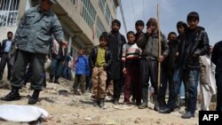 Residents gather at the scene of a roadside bomb attack in Kabul on March 29.