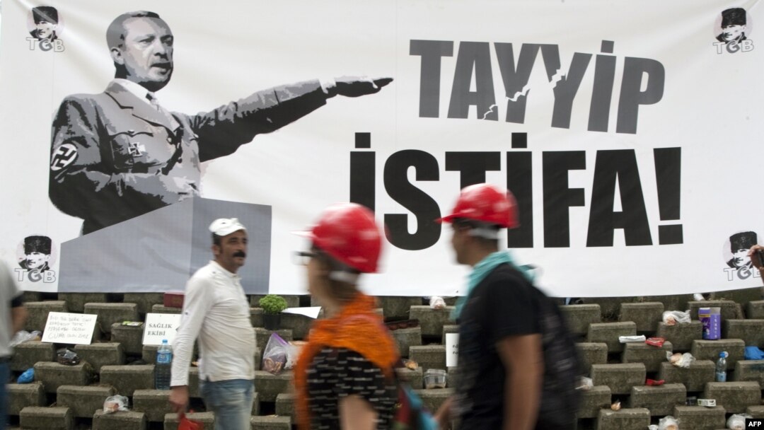 People on Istanbul's Taksim Square pass a banner calling on Prime Minister Recep Tayyip Erdogan to resign. 