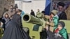 IRAN -- Iranian children pose with howitzer artillery gun during commemorations marking 41 years since the Islamic Revolution, in Tehran, February 11, 2020