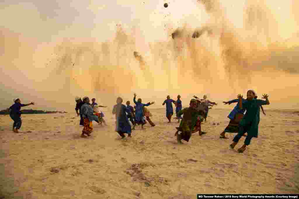 Photographer&nbsp;Tanveer Rohan of Bangladesh: Playing In Dusty Dusk Near Dhakas, children attending a school for religious studies play an improvised game of football.
