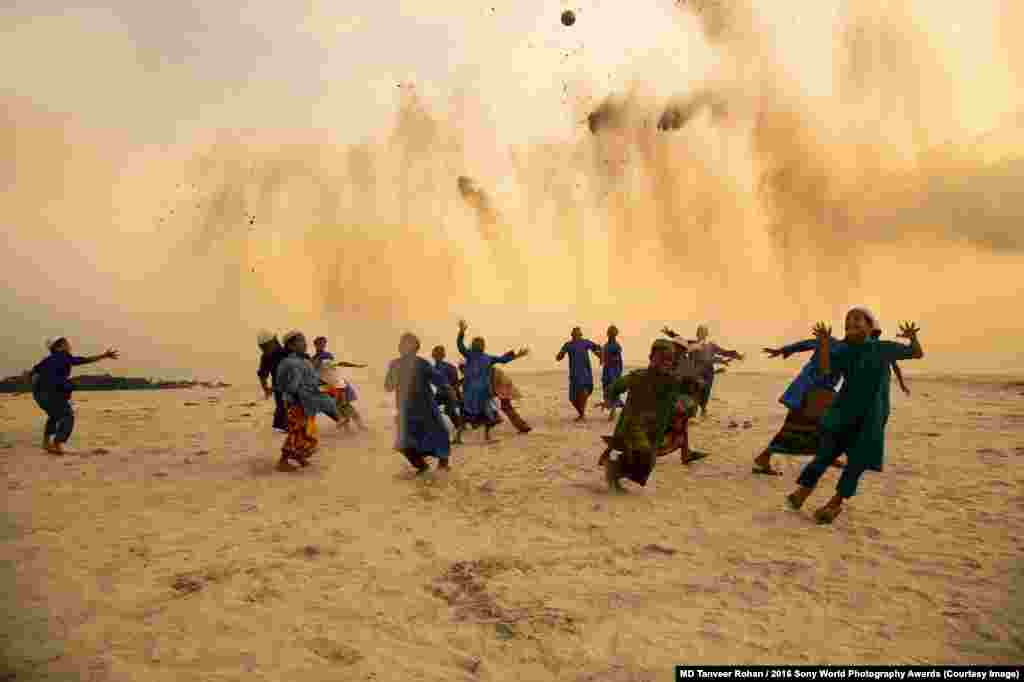 Photographer Tanveer Rohan of Bangladesh: Playing In Dusty Dusk Near Dhakas, children attending a school for religious studies play an improvised game of football.